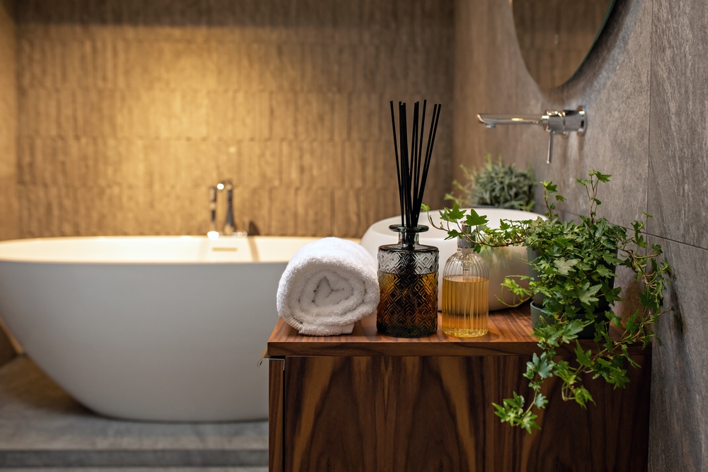 Modern bath room with green plants, aroma sticks, soap.
