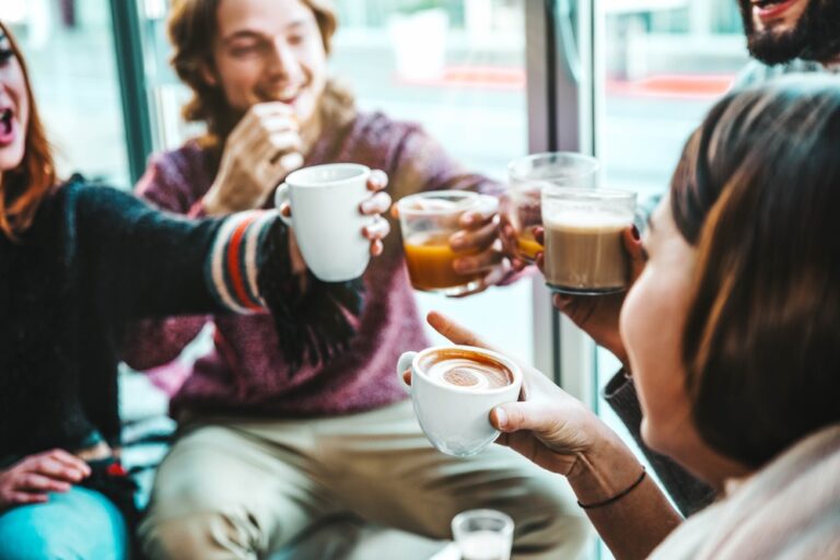 Happy friends having breakfast together at cafe bar - Group of young people drinking coffee and fresh juice sitting at brunch restaurant - Food and drink concept